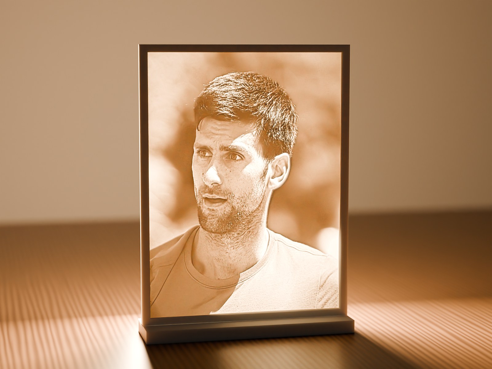 The same lithophane backlit by a warm lamp, revealing a portrait of Novak Djokovic